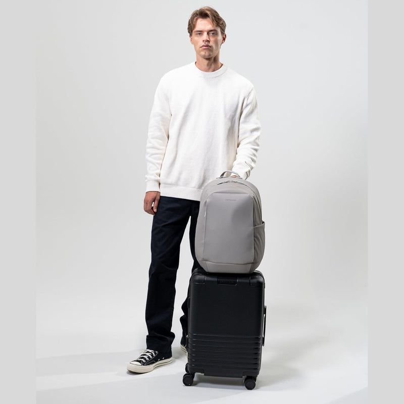 homme voyageant portant valise et kapten & son oslo sac à dos greige