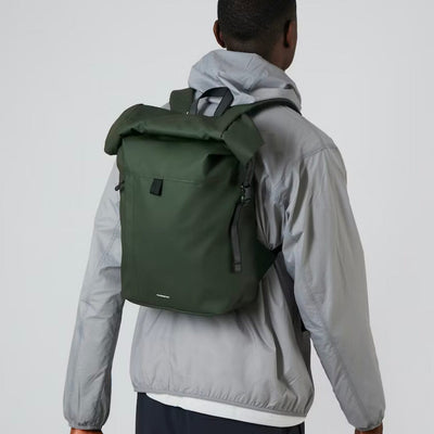 man model wearing small waterproof backpack recycled polyester roll top konrad sandqvist green