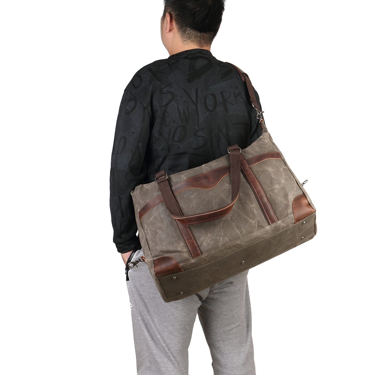 homme portant un sac de voyage toile et cuir vert armée