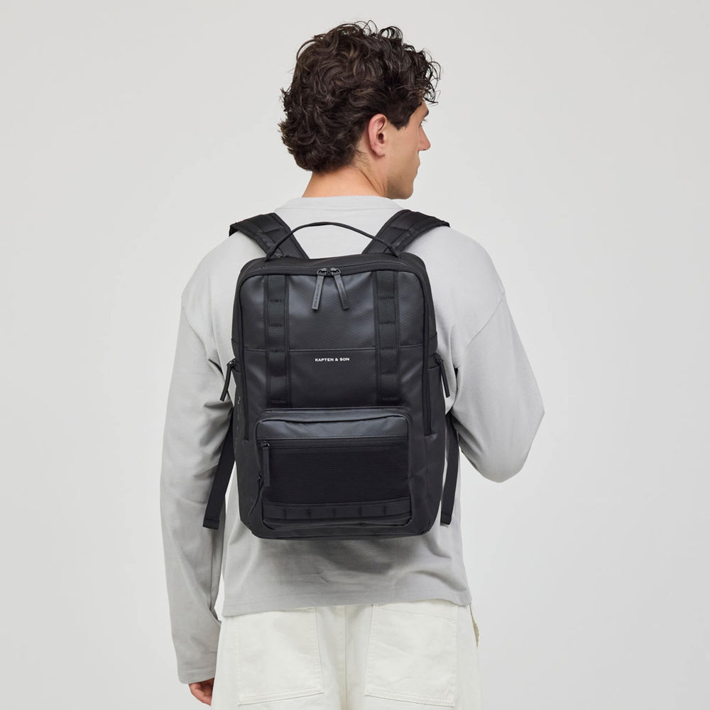 Man wearing the Bergen Ultra backpack in All Black, back view