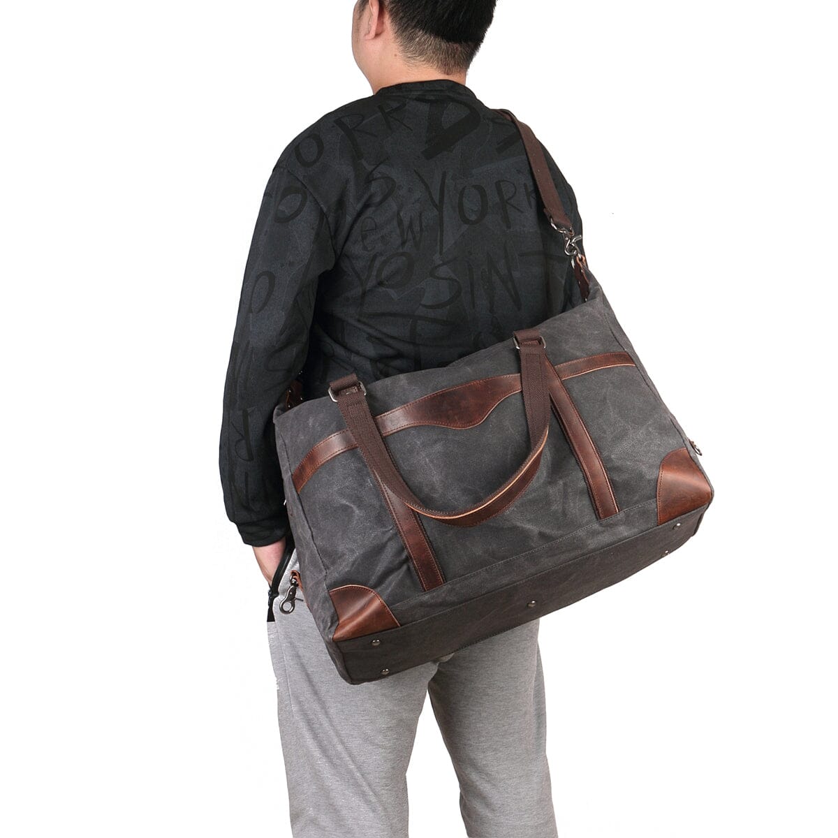 man wearing grey canvas leather duffle bag