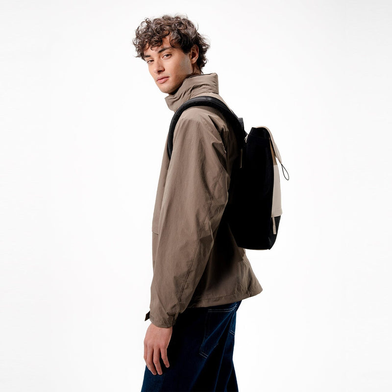 man wearing kapten son fyn backpack cream black, side view