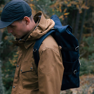 man wilderness wearing eco friendly urban roll top backpack ilon sandqvist navy