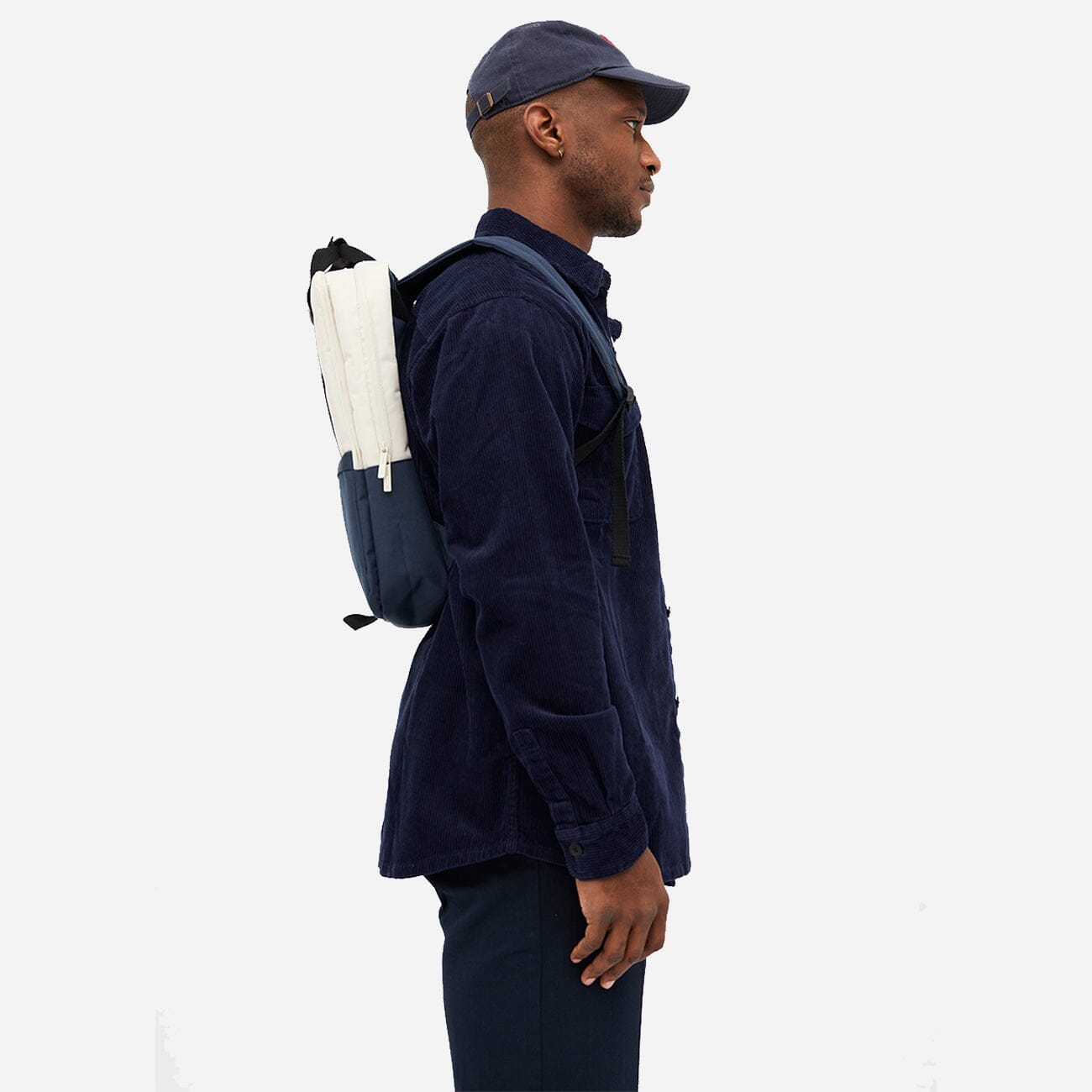 Side view of man carrying a sustainable blue and white backpack