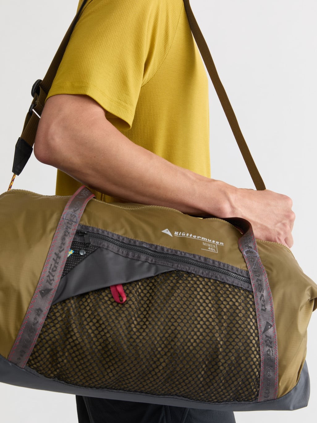 Mimer Duffelbag 40L in Olive carried on the shoulder, front mesh pocket close-up