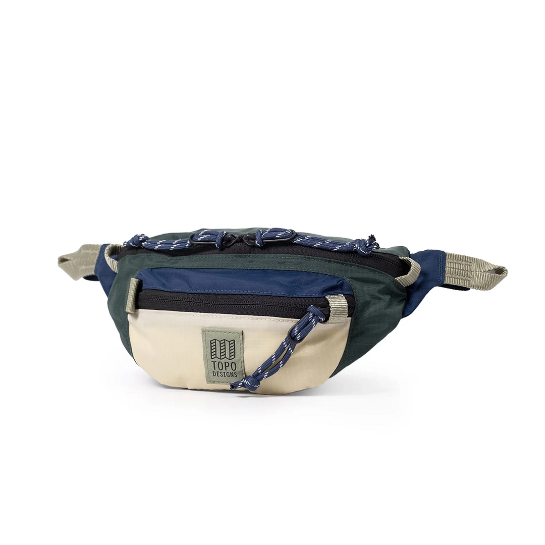 Side view of the Mountain Waist Pack 1L in forest and bone white showing the adjustable webbing strap