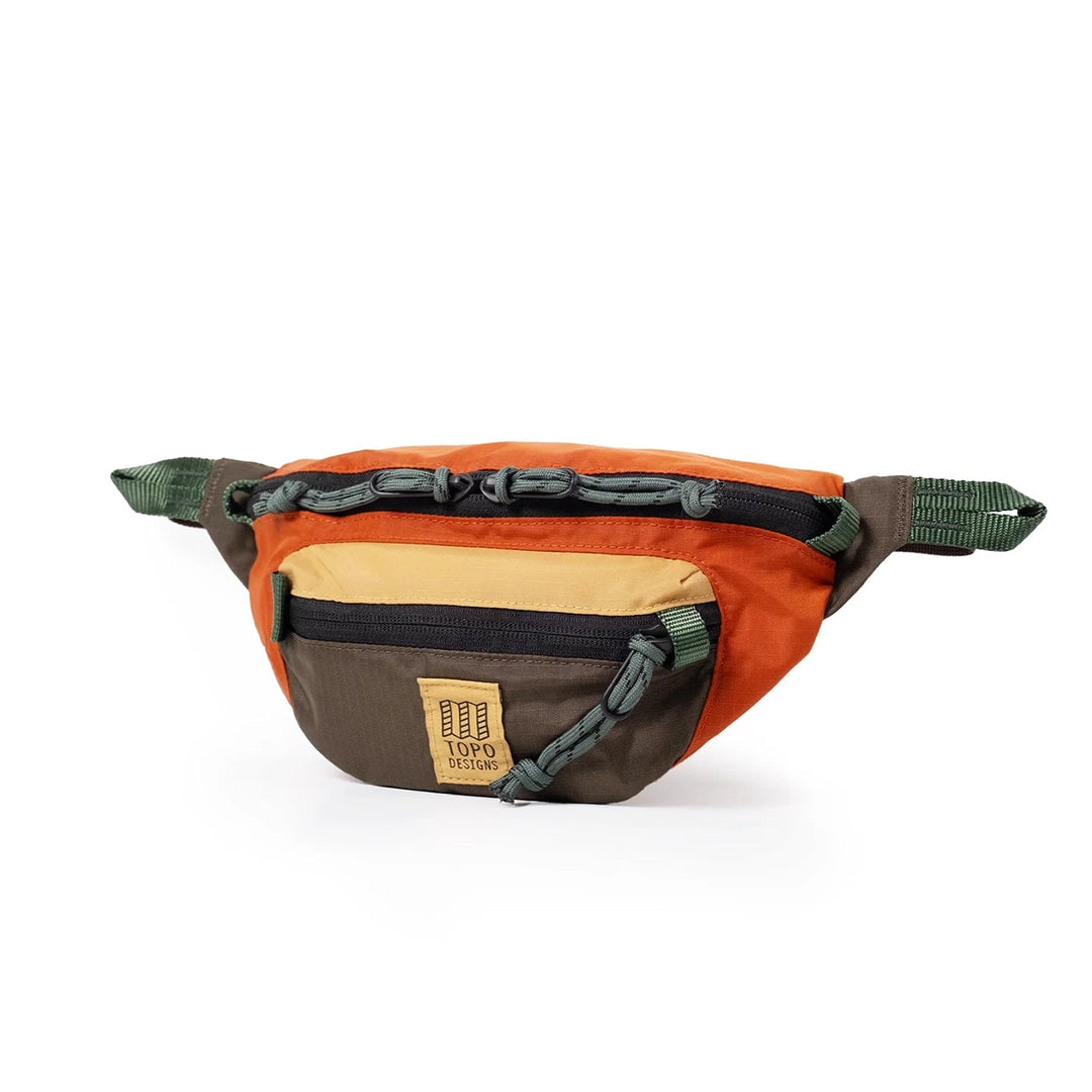 Side view of the Mountain Waist Pack 1L in woodland and terracotta with sage adjustable webbing