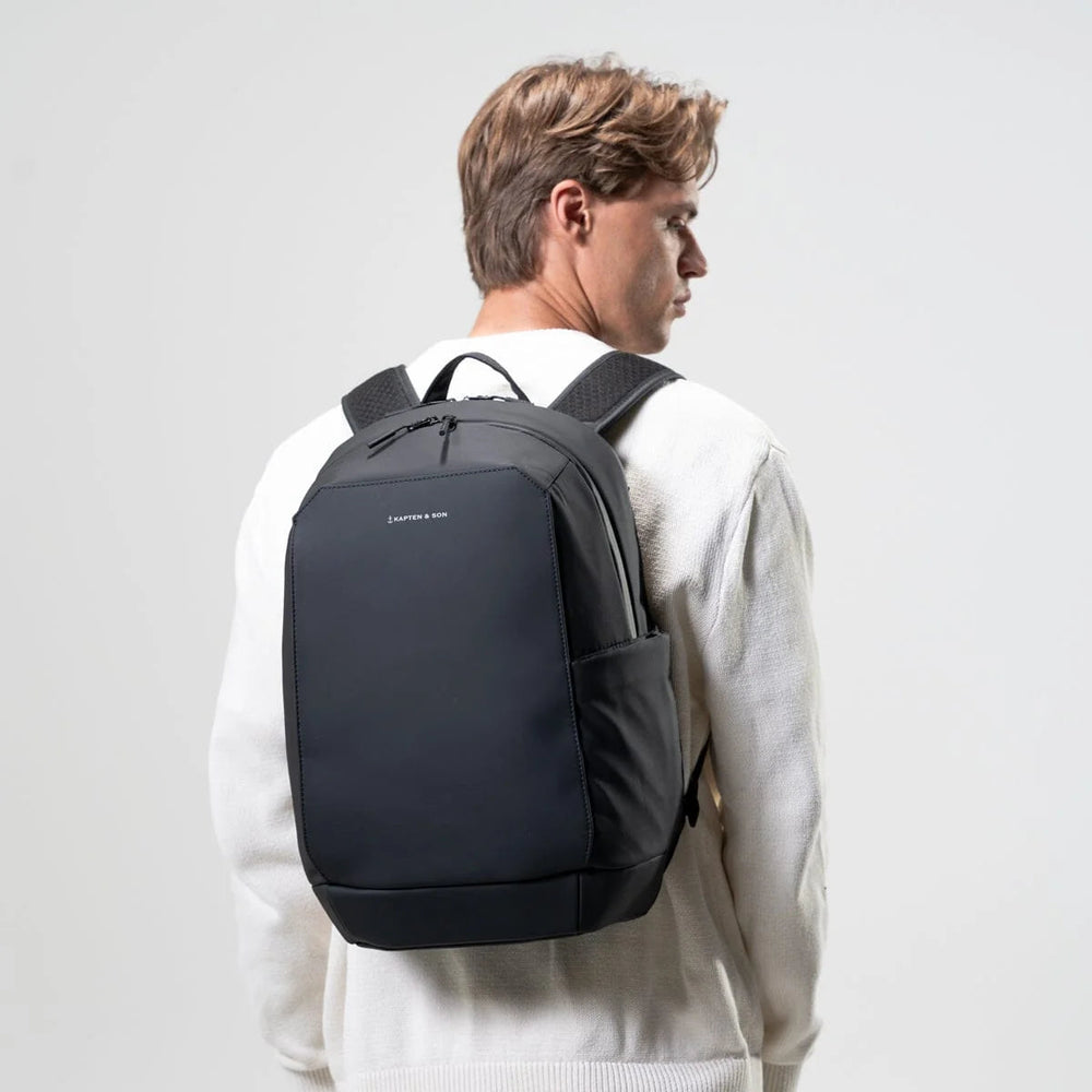 Man wearing the black Oslo backpack, side profile view