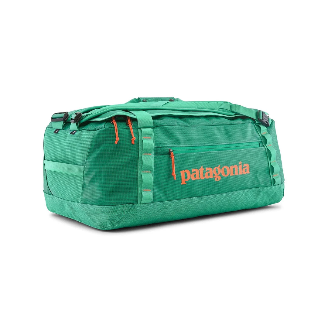Patagonia Black Hole Duffel 55L Aqua Stone — side view in duffel mode with orange Patagonia logo