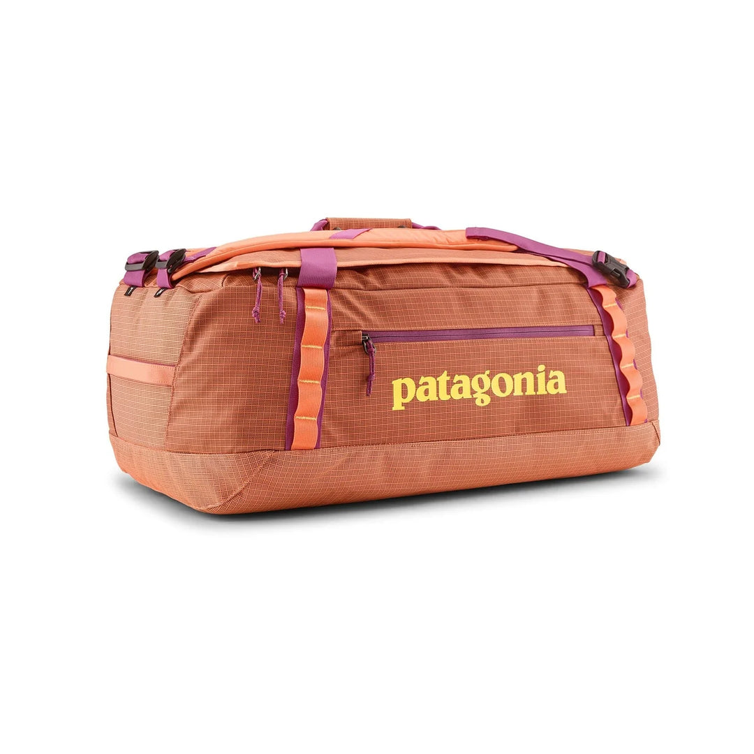 Patagonia Black Hole Duffel 55L Peach Sherbet — side view in duffel mode with yellow logo