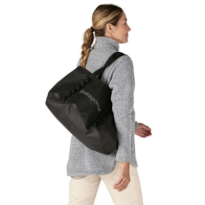 Black Patagonia tote worn cross-shoulder, cozy urban look