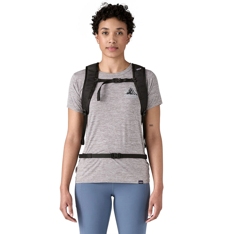 Woman facing forward wearing a compact Patagonia daypack with adjustable sternum and hip straps
