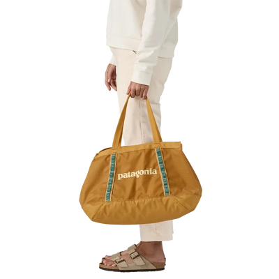 Minimal tote bag in mustard yellow held by hand, practical for daily use