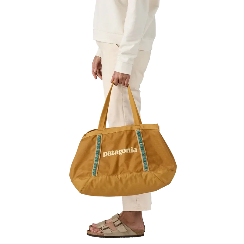 Minimal tote bag in mustard yellow held by hand, practical for daily use