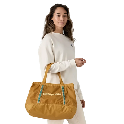 Woman carrying a mustard Patagonia tote bag over the shoulder, casual and roomy