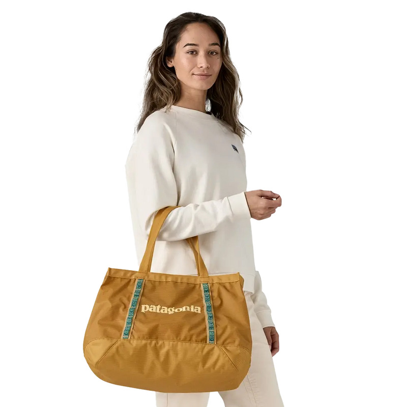 Woman carrying a mustard Patagonia tote bag over the shoulder, casual and roomy