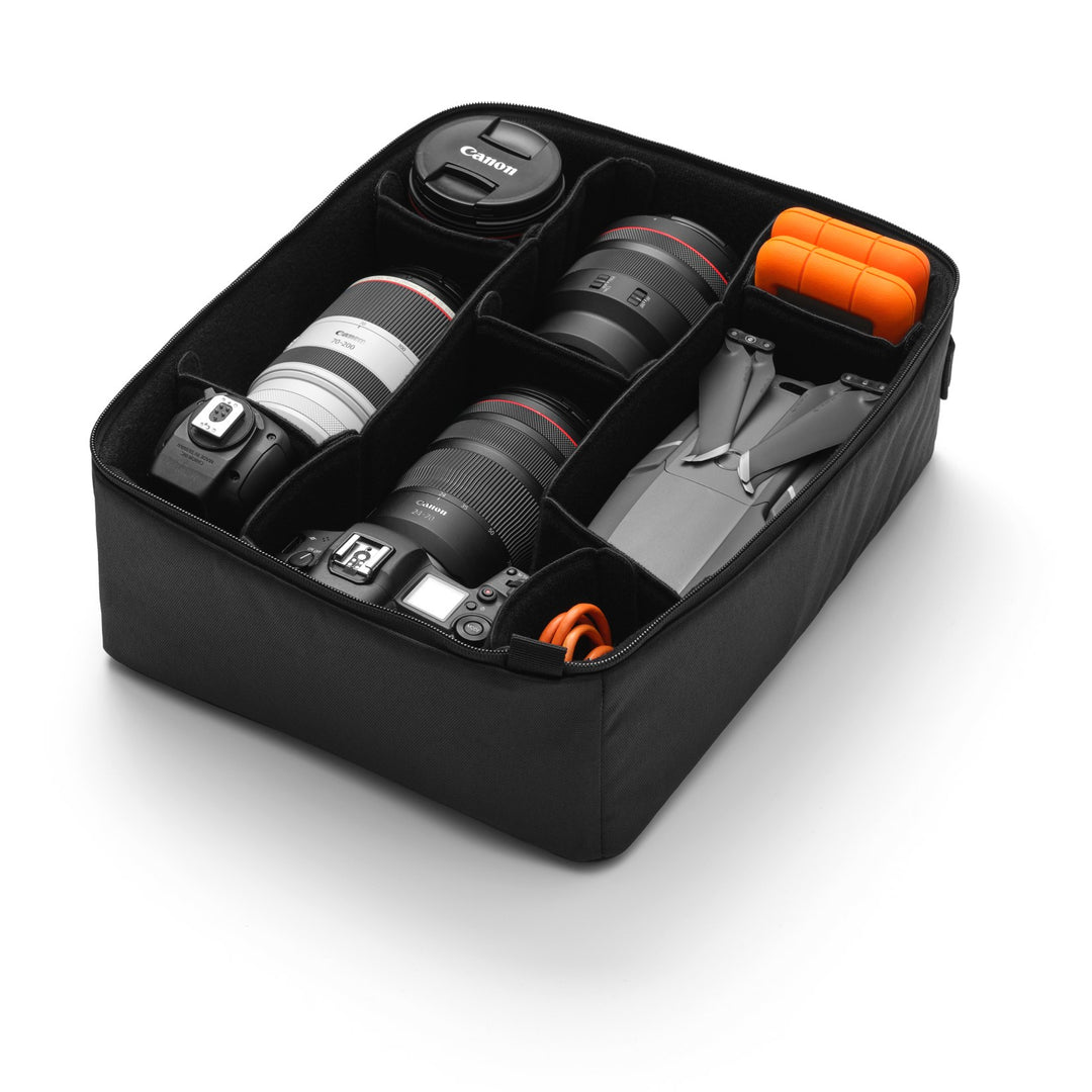 Ramverk Camera Insert M, open with camera bodies, lenses and a drone held by the dividers