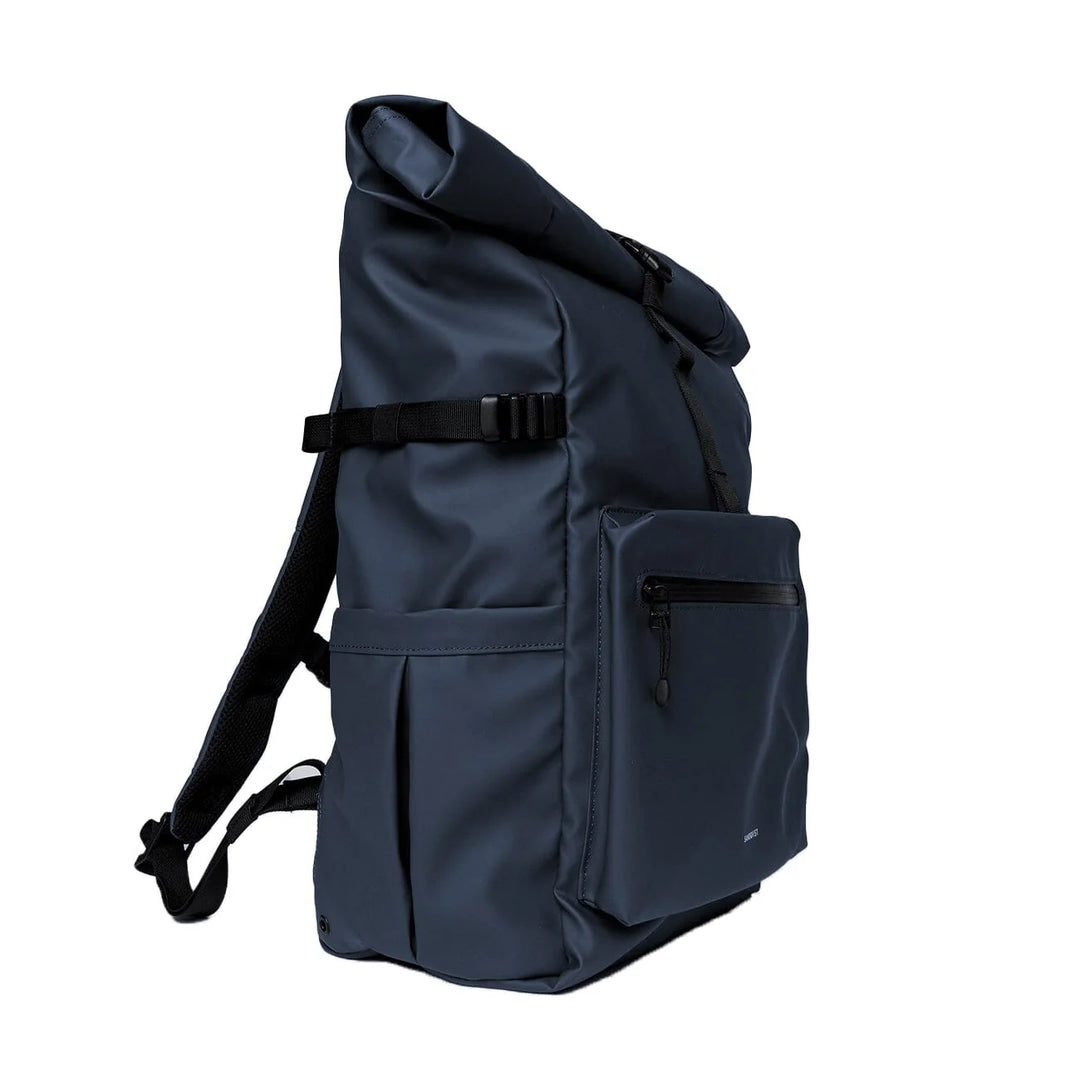 Woman wearing Sandqvist Stream Rolltop Backpack L in dawn green, side profile