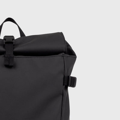 Rolltop closure of the black slim backpack with buckle fastening, combining waterproof protection with minimalist style