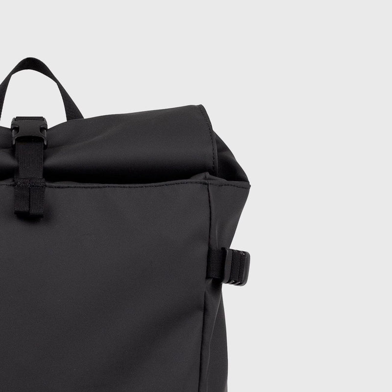 Rolltop closure of the black slim backpack with buckle fastening, combining waterproof protection with minimalist style