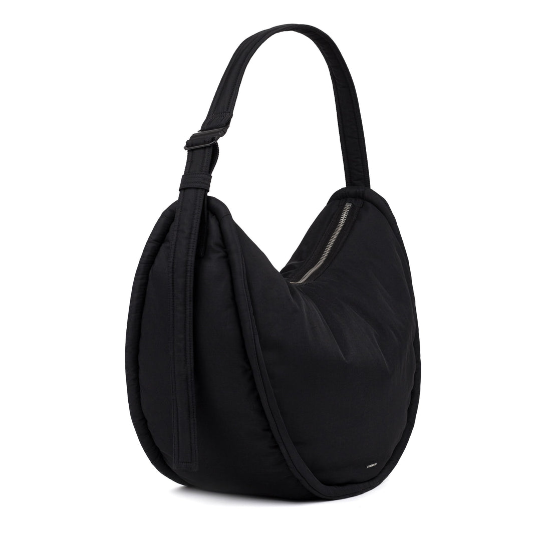Sandqvist Curve Half Moon Bag in black — three-quarter view of the curved nylon silhouette