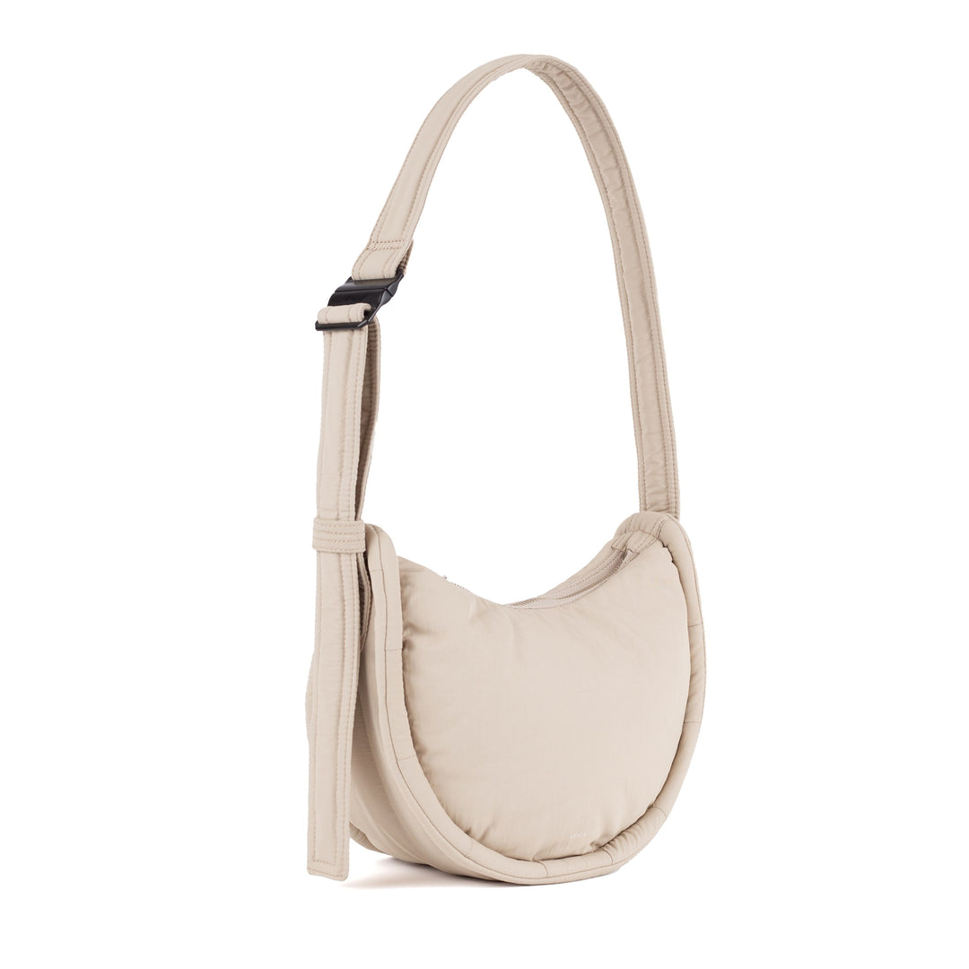 Sandqvist Curve Half Moon Bag Mini in beige — three-quarter view of the small half-moon bag