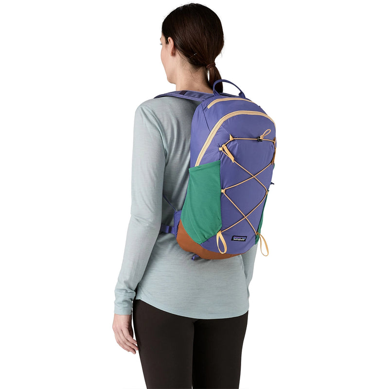 Rear view of a woman with a colorful Solstice Purple hiking backpack, green side pockets visible