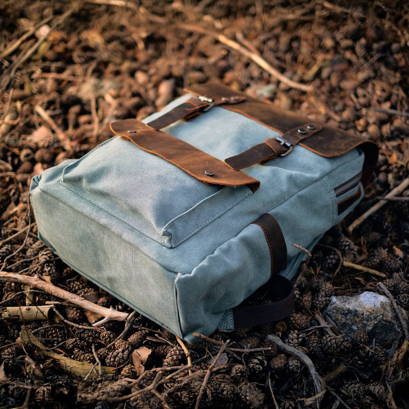 vintage canvas and leather bookbag Helsinki laying on forest ground