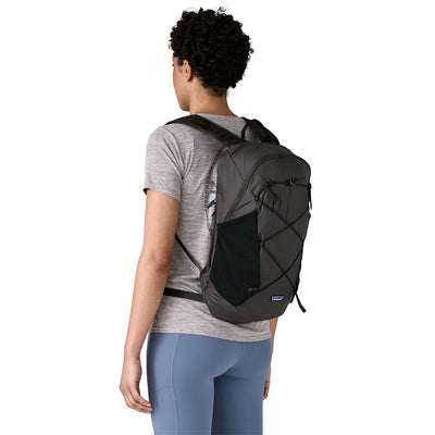 Lightweight black hiking backpack worn by a woman, shown from behind on trail