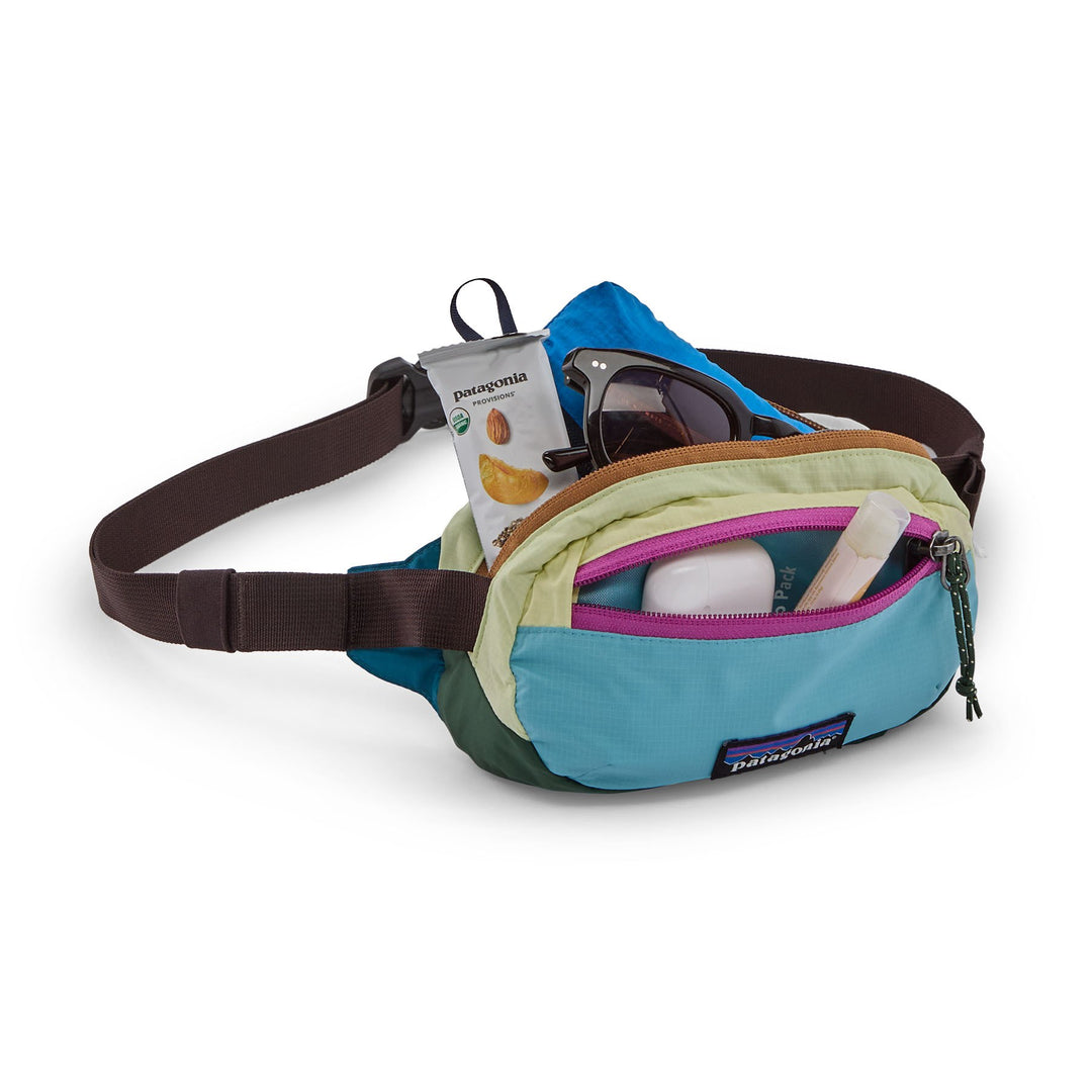 Terravia Mini Hip Pack in Patchwork Snowmelt Blue open, showing sunglasses and small essentials inside