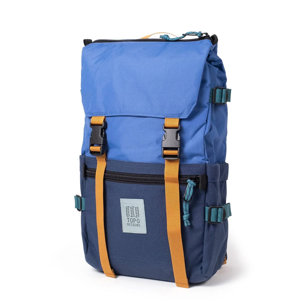 The Rover Pack Classic in cobalt and midnight — three-quarter view with teal buckles and yellow webbing