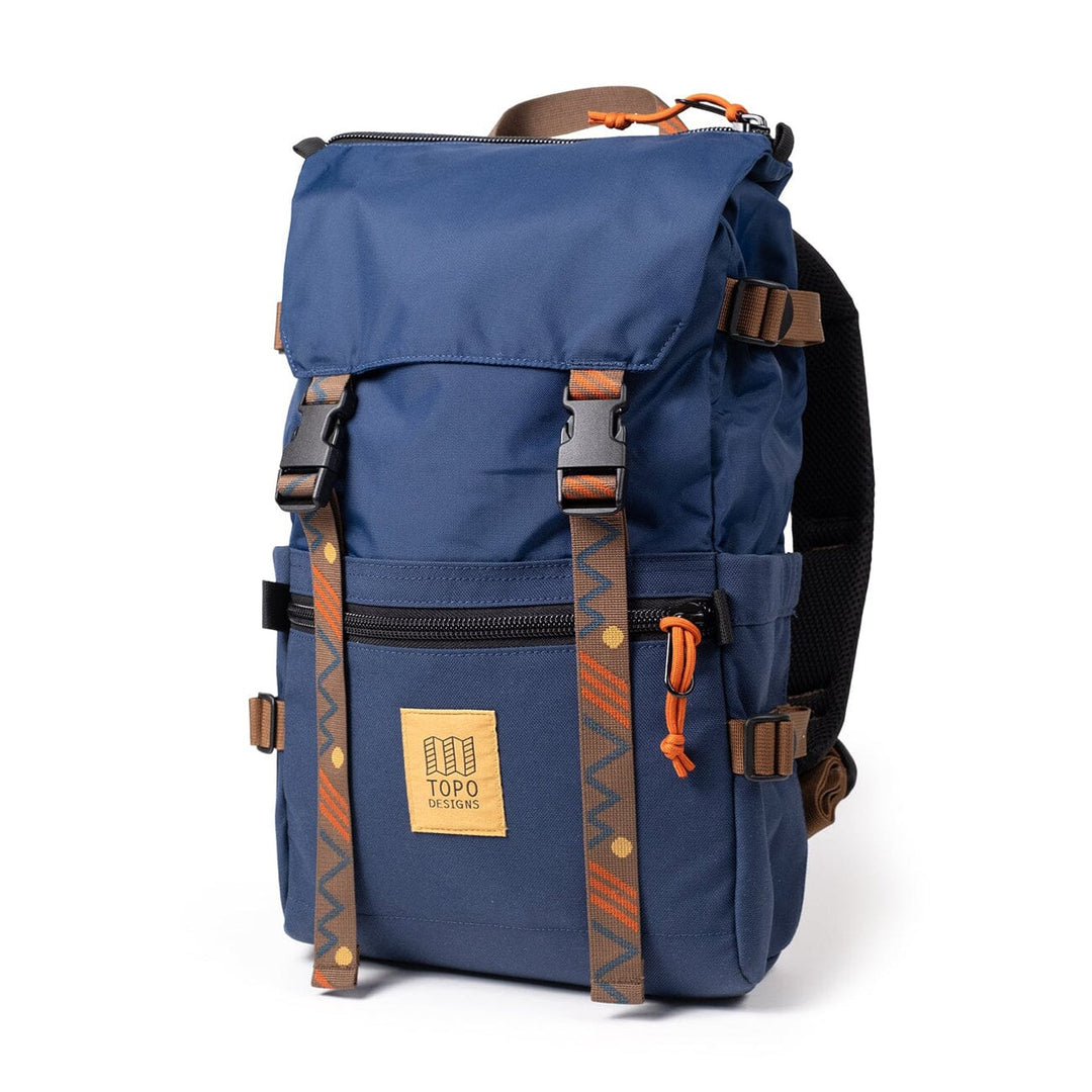 The Rover Pack Classic in midnight navy — three-quarter view with zigzag webbing and orange accents