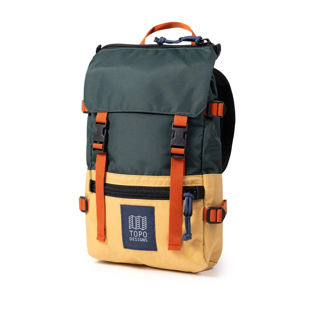 The Rover Pack Mini in forest and goldenrod — three-quarter angle with side mesh pocket and orange straps