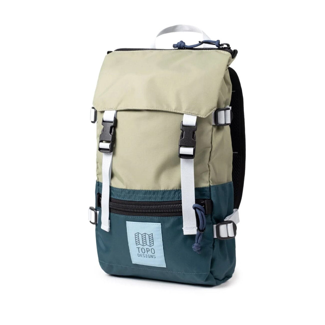 The Rover Pack Mini in oil green and dark pine — three-quarter angle with side mesh pocket and white straps