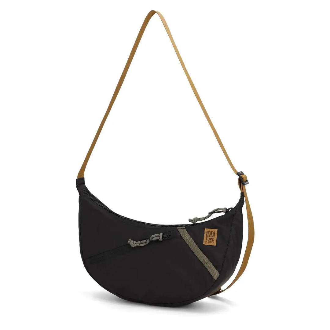Side profile of the Topo Designs Moonlight crescent bag with curved shape and adjustable strap