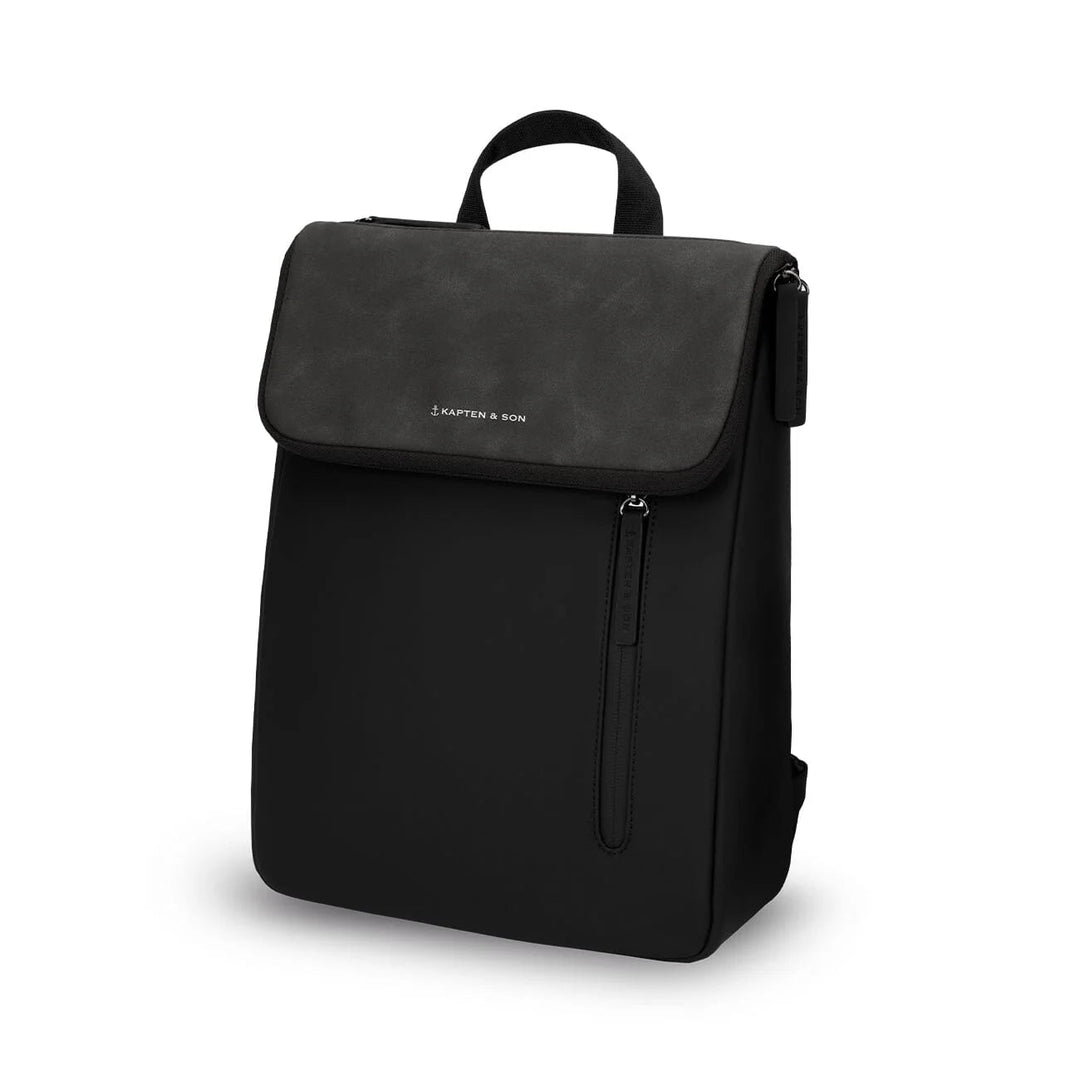 Three-quarter view of the Vallen small backpack in black showing the textured suede flap and clean minimalist silhouette
