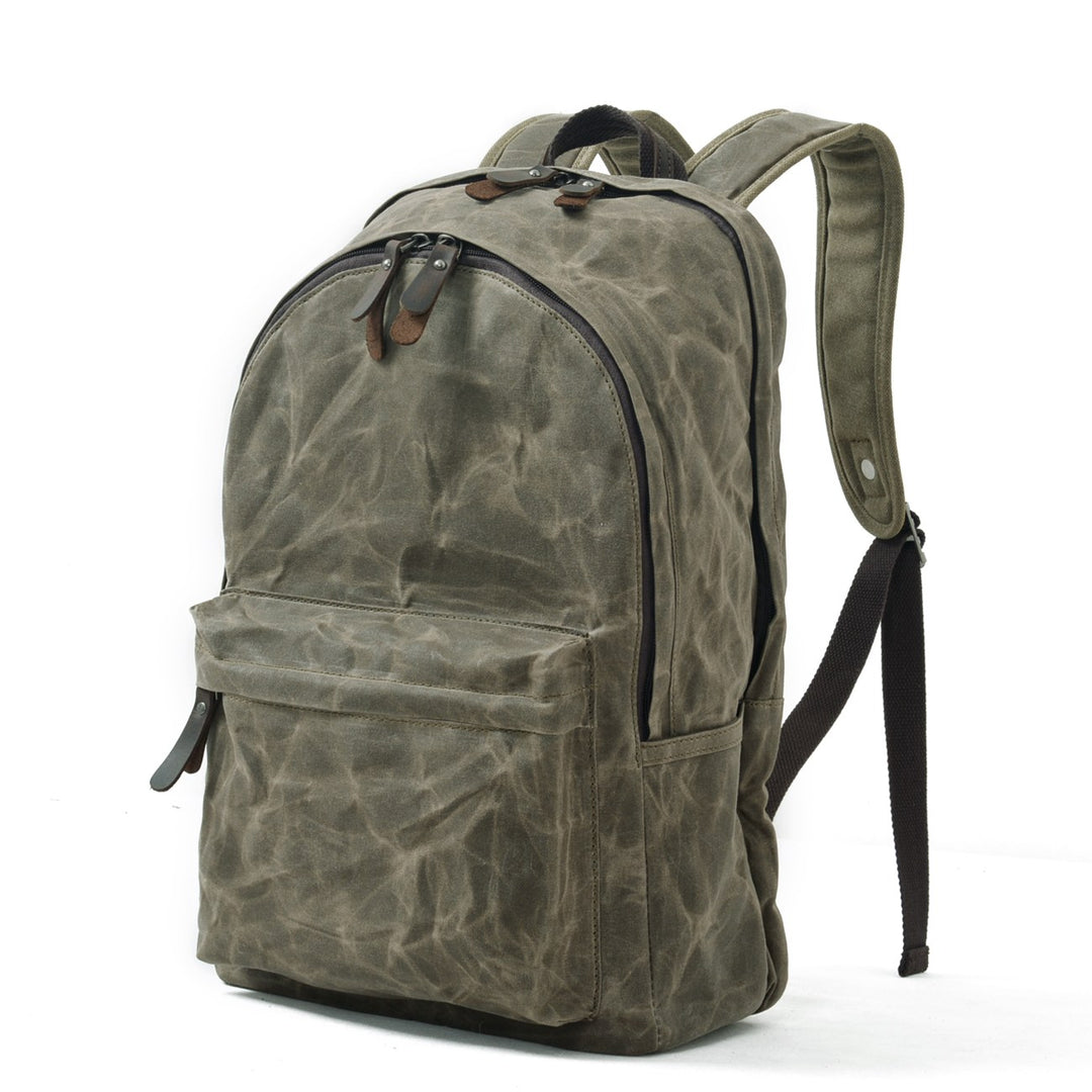 Three-quarter view of the Aberdeen in army green waxed cotton canvas, showing the curved top zip, front pocket and padded shoulder straps