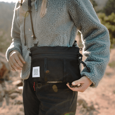 woman hiker wearing black topo designs mountain accessory shoulder bag