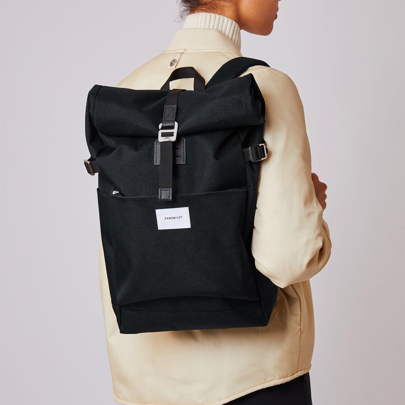 woman model wearing eco friendly urban roll top backpack ilon sandqvist black
