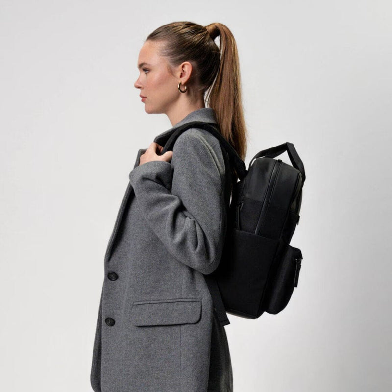 woman wearing all black bergen pro backpack kapten son