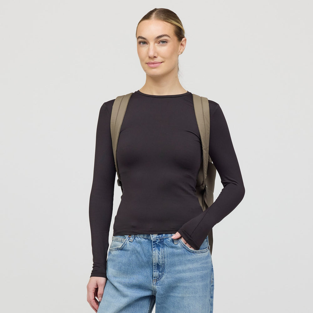 Woman wearing the Bergen Cloud walnut backpack, front view with straps over the shoulders