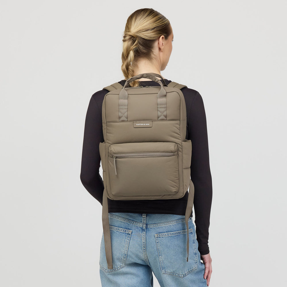 Woman wearing the Bergen Cloud walnut backpack, rear view