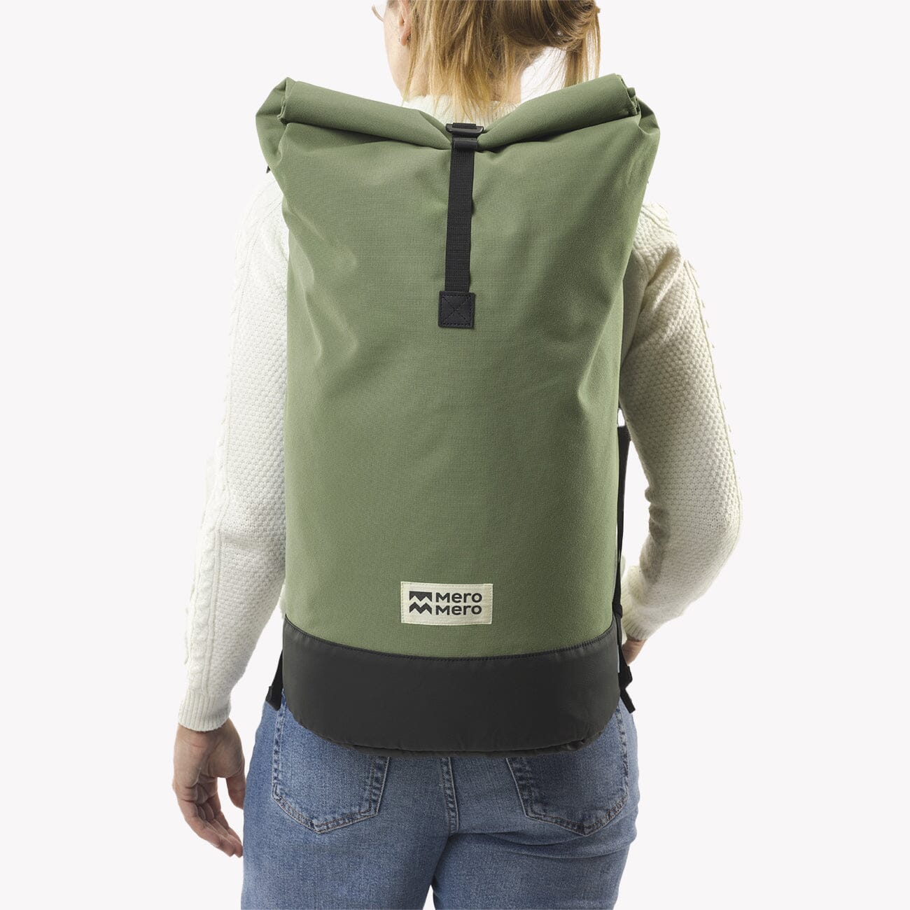 woman wearing cypress green roll top squamish backpack mero mero rolled back view