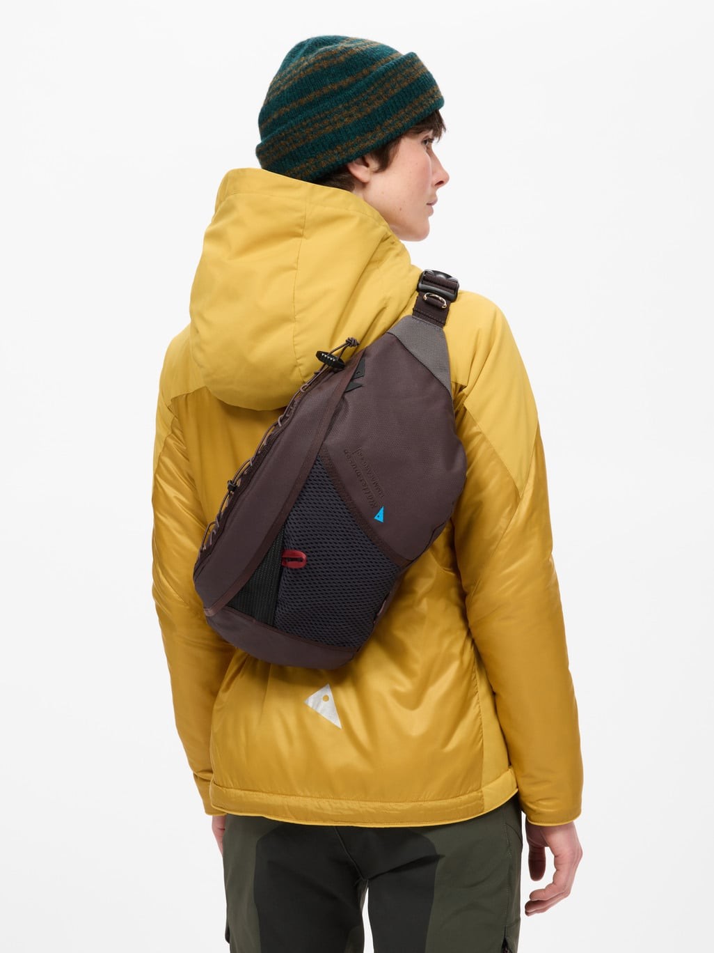 Woman wearing the Fimmafäng 4.0 7L in Brown Umber across the back as a sling