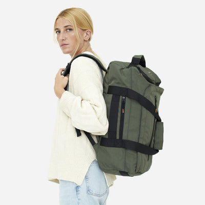 woman wearing green convertible backpack perfect for eco conscious travelers side view