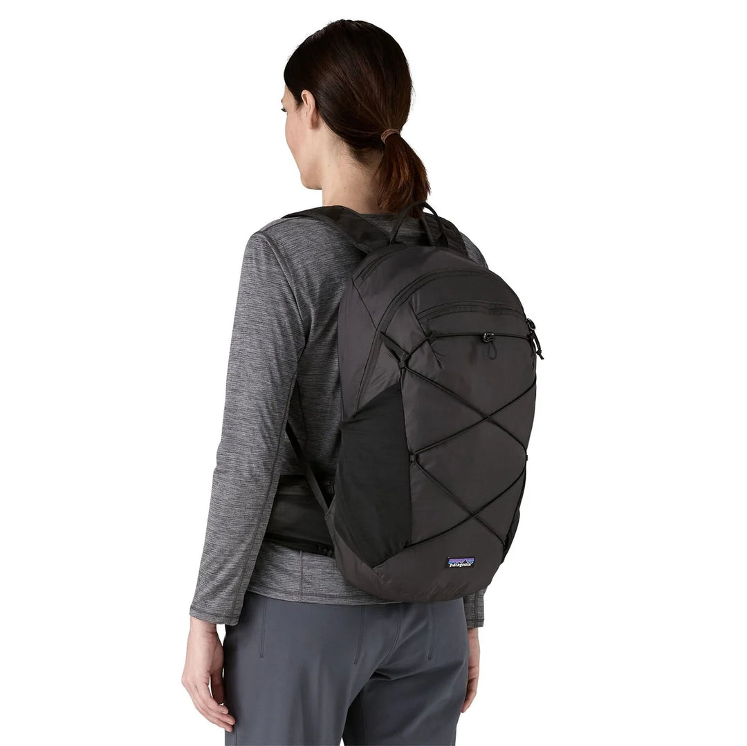 Woman wearing the Terravia 22L Black seen from the back showing the bungee cord system