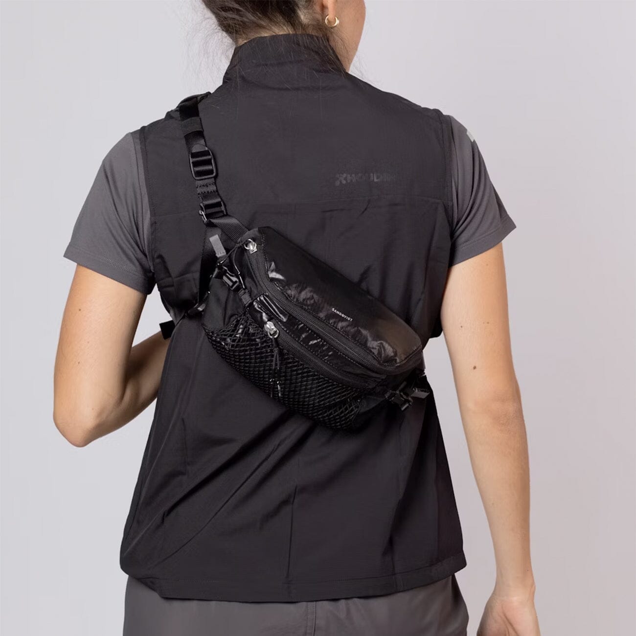 woman wearing sandqvist lo all black crossbody bag back