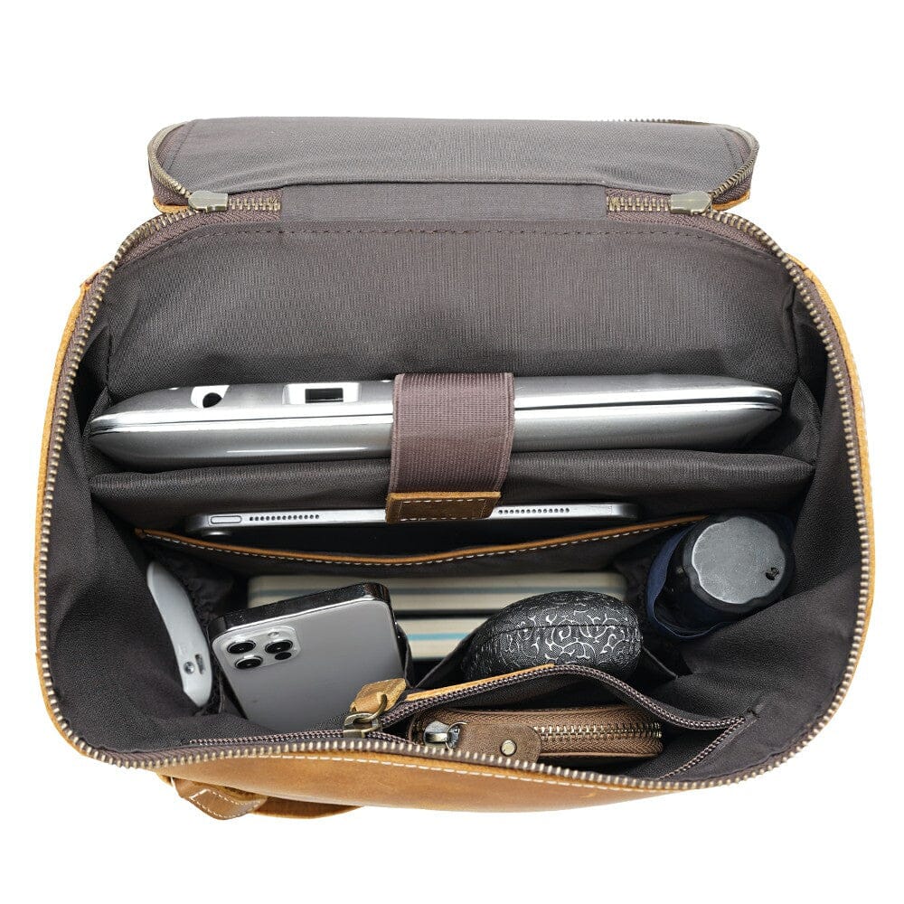inside of a brown leather small backpack filled with a laptop, ipad and other valuables