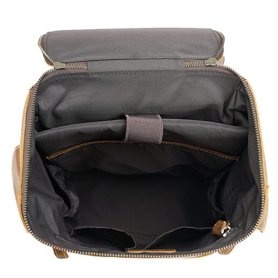 inside compartments of a brown leather small backpack with laptop sleeve