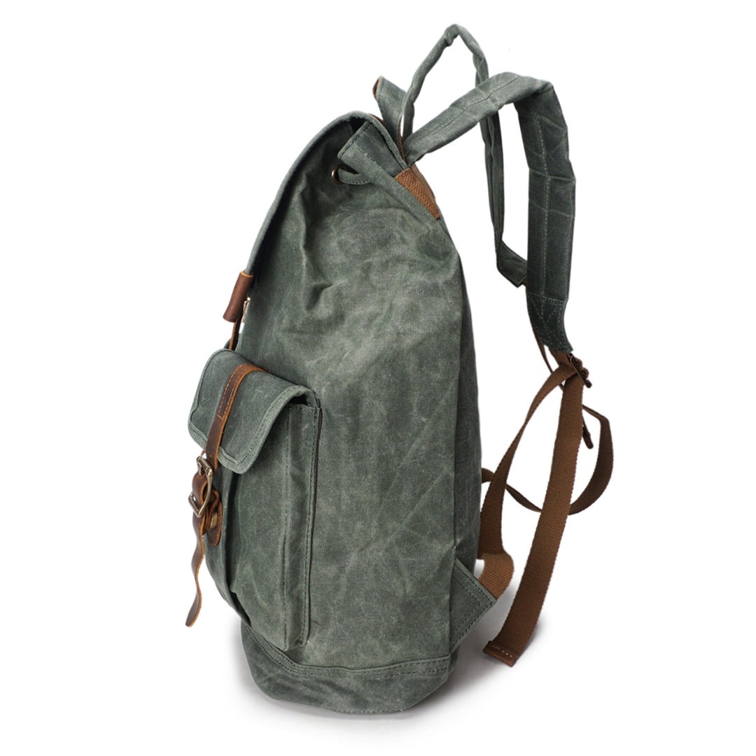 Angle view of the Karlstad leather and canvas rucksack showing leather flap and brass hardware